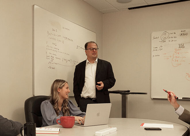 An IT professional speaking in front of a white board.
