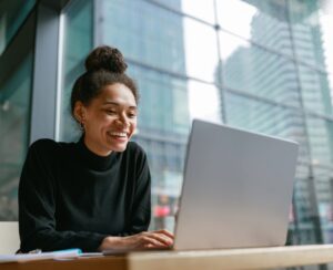 Professional working remotely with laptop using cloud infrastructure for distributed team collaboration