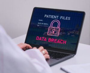HIPAA compliance data breach warning on laptop showing patient files security risk for Northeast Ohio healthcare providers